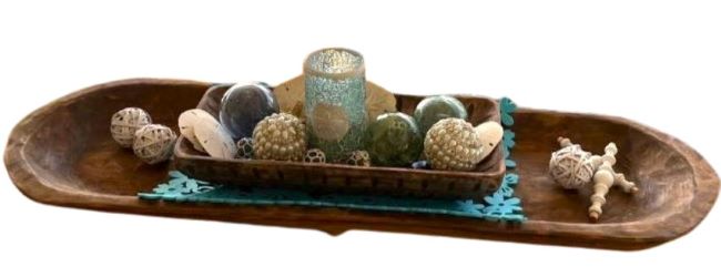 long wooden dough bowl filled with shells and glass balls