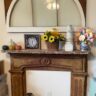 Old window hung over salvaged fireplace mantel