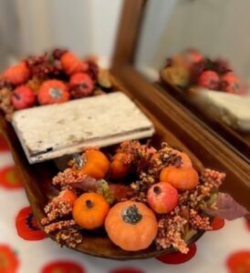 wooden riser, two artificial berry and pumpkin candle rings in a dough bowl