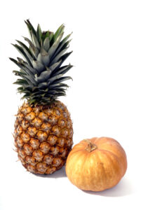 single pineapple and a small pumpkin