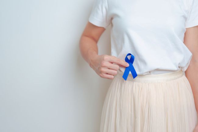 female holding a blue ribbon near her waist