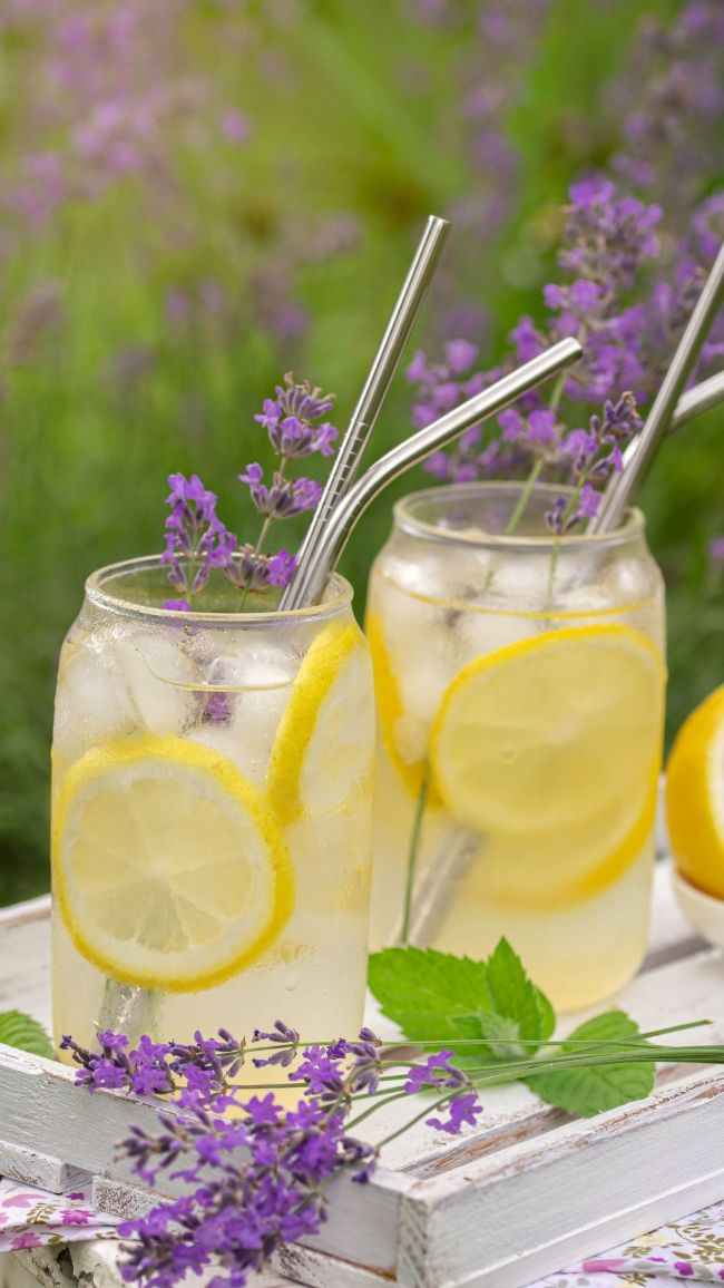 two glasses of lavender lemonade on a wood tray