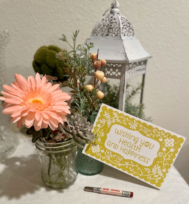 assorted silk flowers in mason jar, lantern, campaign pencil