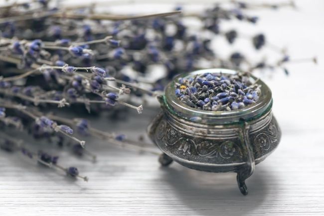 dried lavender sprigs on rustic table with silver compote filled with lavender buds