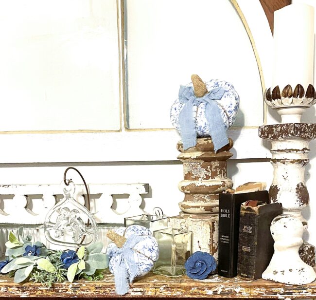 reclaimed fireplace mantel with architectural salvage pieces, heritage bibles, faux florals and soft fabric pumpkins