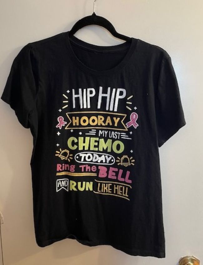 black cotton t shirt with writing on front . Writing pertains to end of cancer treatment