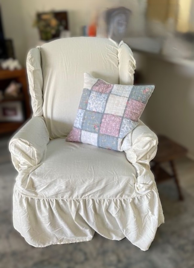 outdated wing chair refreshed with a ready made slipcover & accented with a pretty pillow